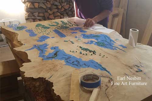 Earl placing turquoise into voids and cracks of cluster burl maple coffee table